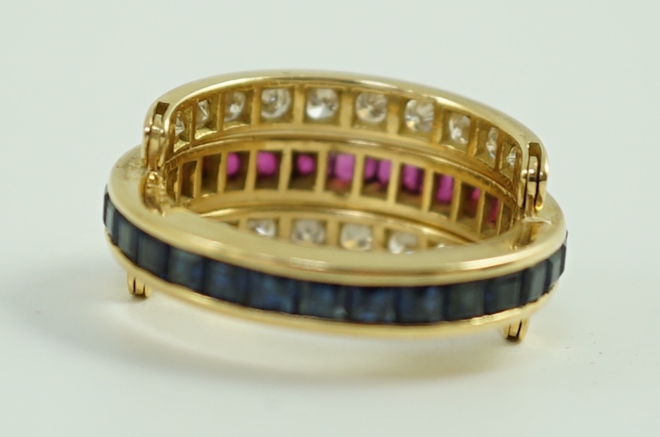 An 18k gold, ruby, sapphire and diamond set triple band swivel ring